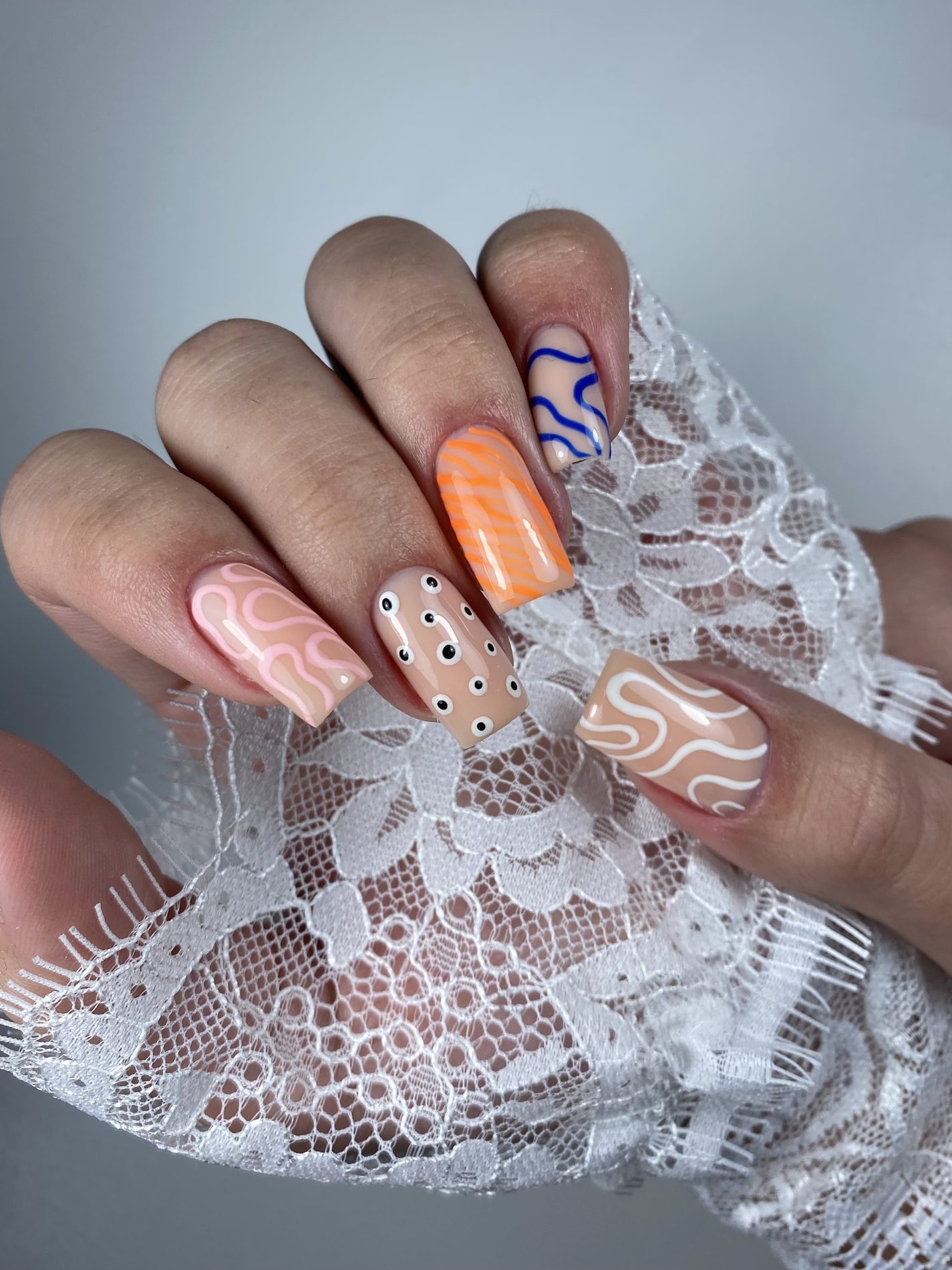 Handgeschilderde swirls, stippen en golven in pastel op kant