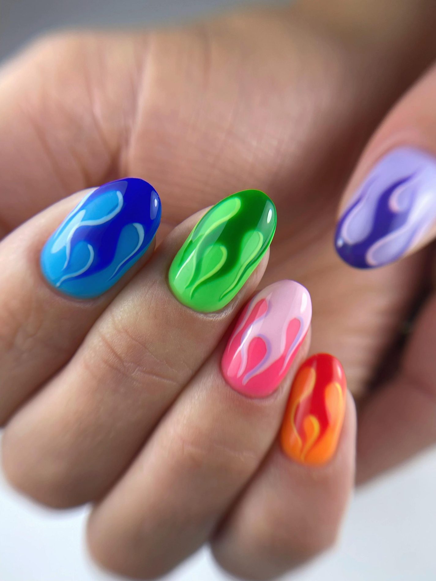 Nagels in blauw, groen, roze en oranje met vlammen