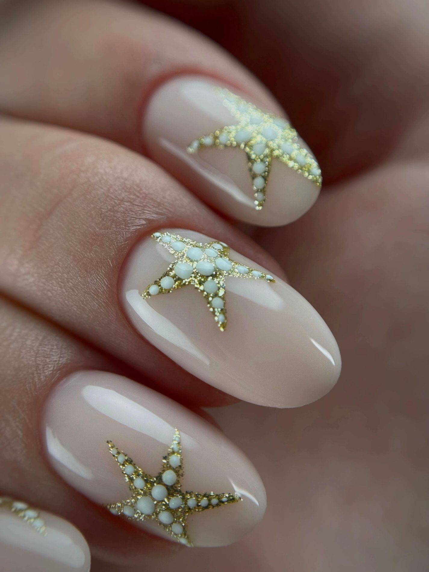 Melkwitte amandelnagels met kleine 3D-zeesterren
