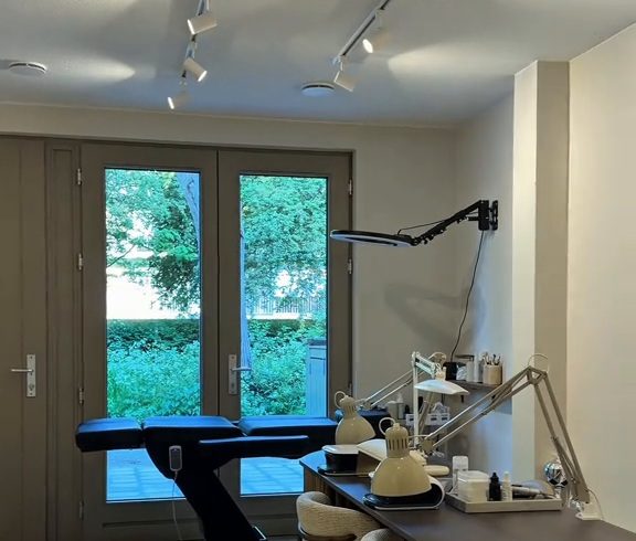De behandelruimte van Refined Beauty met tuindeuren, behandelstoel en nageltafel